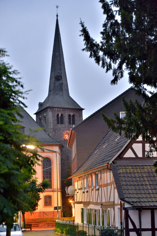 Kirchturm und Fachwerkhaus in der Dämmerung