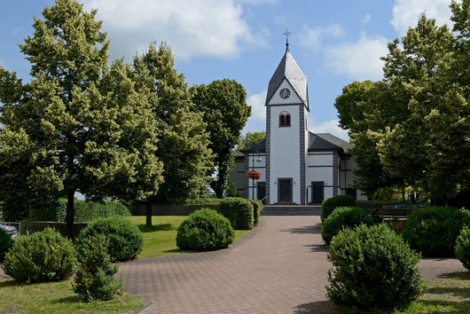 weiße Kirche zwischen grünen Bäumen