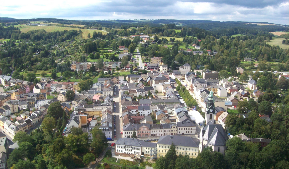 Luftbild der Stadt Adorf mit vielen grauen Dächern und grüner Landschaft