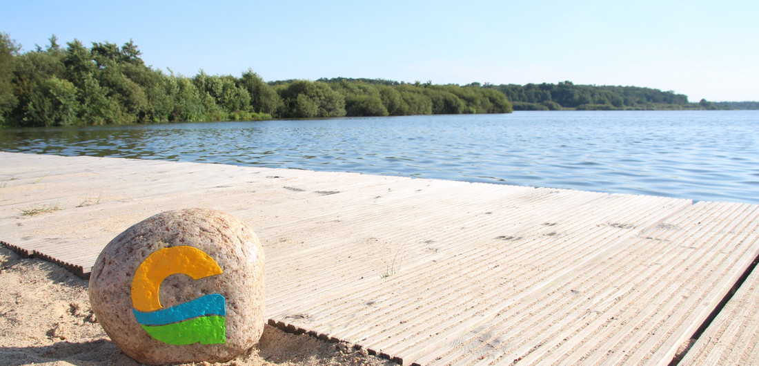 Sandstrand und See Bad Bederkesa mit Stein und Logo der Stadt Geestland