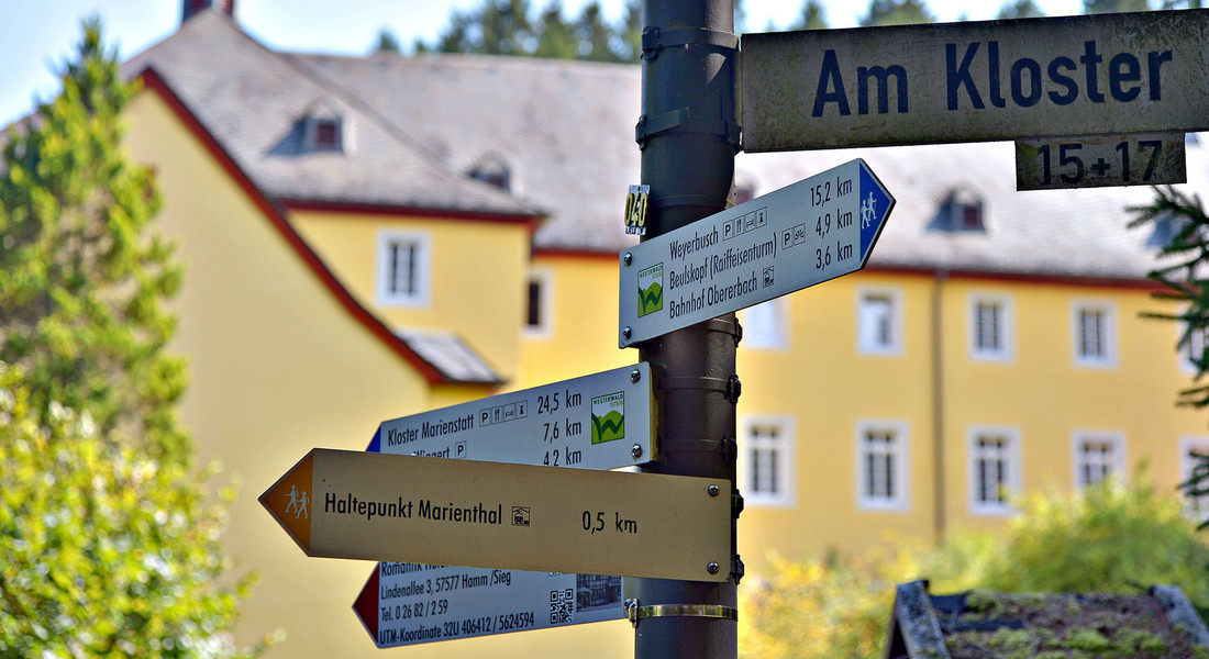 Ein Wegweiser für Ausflugsziele und ein Straßenschild "Am Kloster"