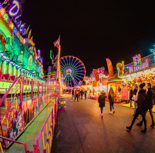 Eine Kirmes mit vielen bunten Lichtern im Dunkeln