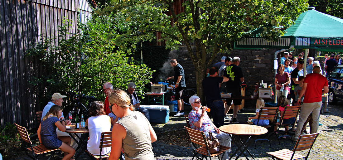 Menschen bei einem Grillfest in einem Innenhof