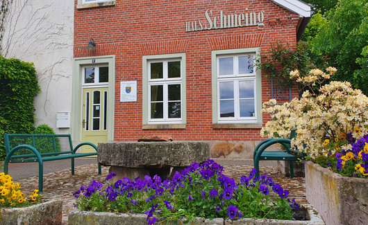 Rotes Haus mit gelben und lila Blumen