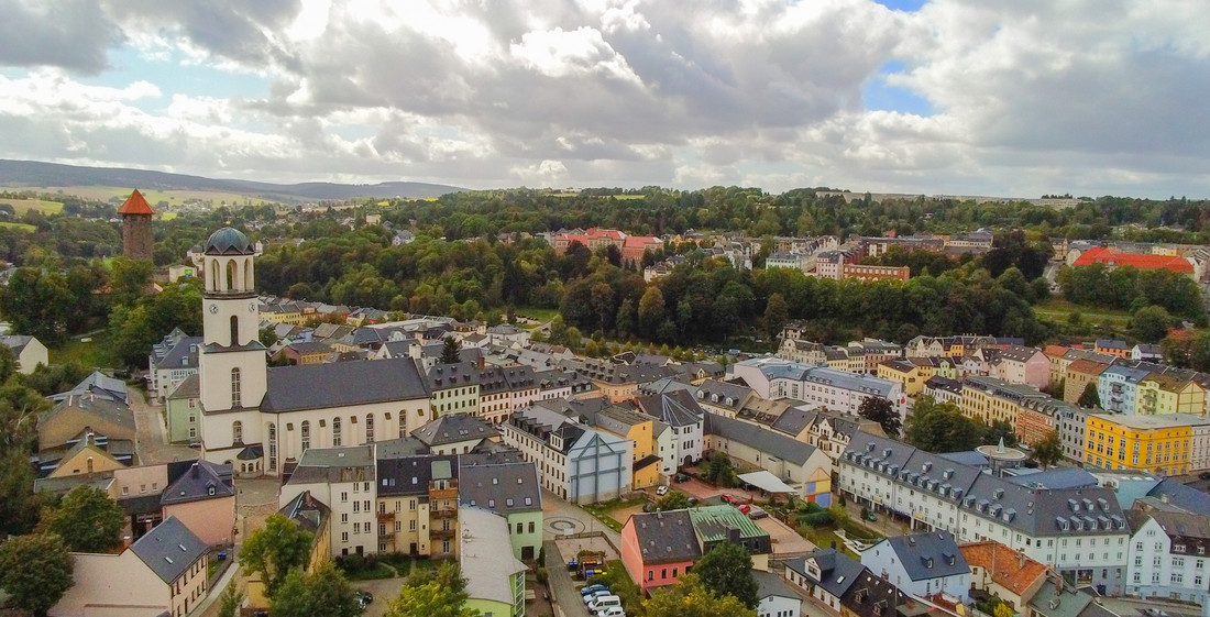 Ein Dorf mit bunten Fassaden und zwei Kirchtürmen.