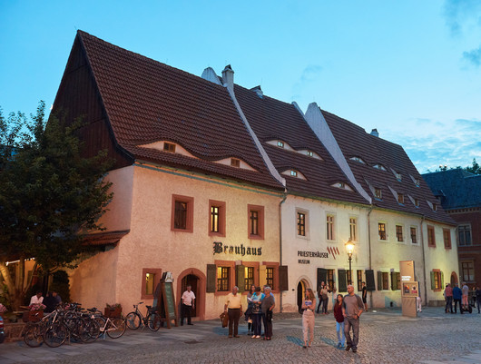 Alte Wohnhäuser in der Dämmerung mit Spaziergängern