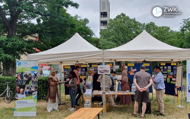 Stände der Quartierskonferenz in Frankfurt Kuhwald. Links ein Aufsteller des Modellprojektes Zukunftswerkstatt Kommunen (ZWK)